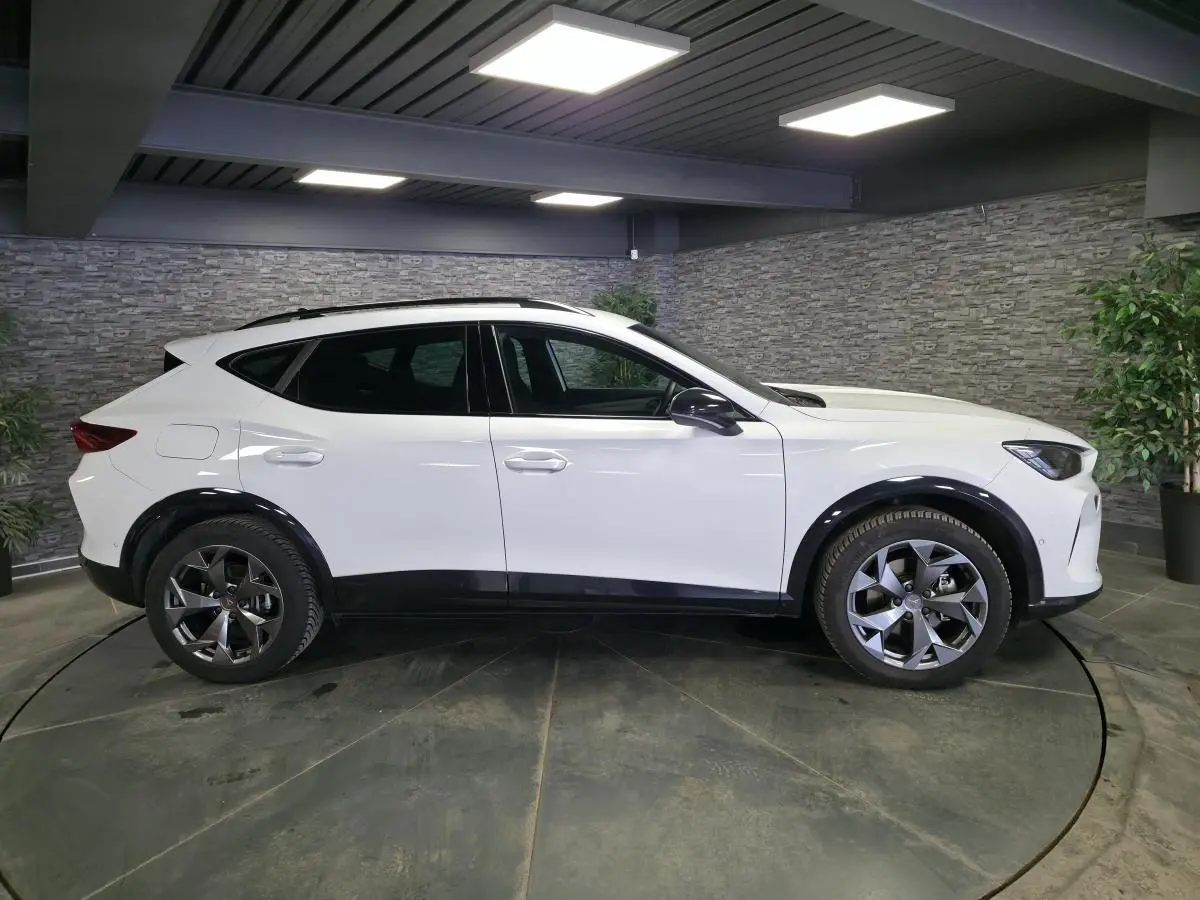 Vue de profil côté gauche d’un CUPRA Formentor blanc avec jantes alliage 18 pouces et bas de caisse noirs.