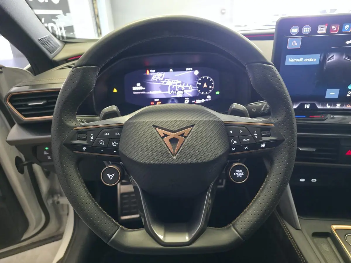 Vue rapprochée du volant cuir perforé avec logo CUPRA cuivré et tableau de bord digital du Formentor 1.5 eTSI Hybrid.