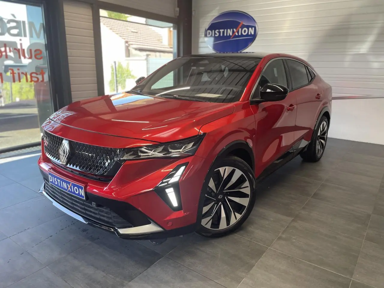 Renault Rafale rouge à toit noir, vue 3/4 avant droit, avec calandre noire et feux LED distinctifs allumés.