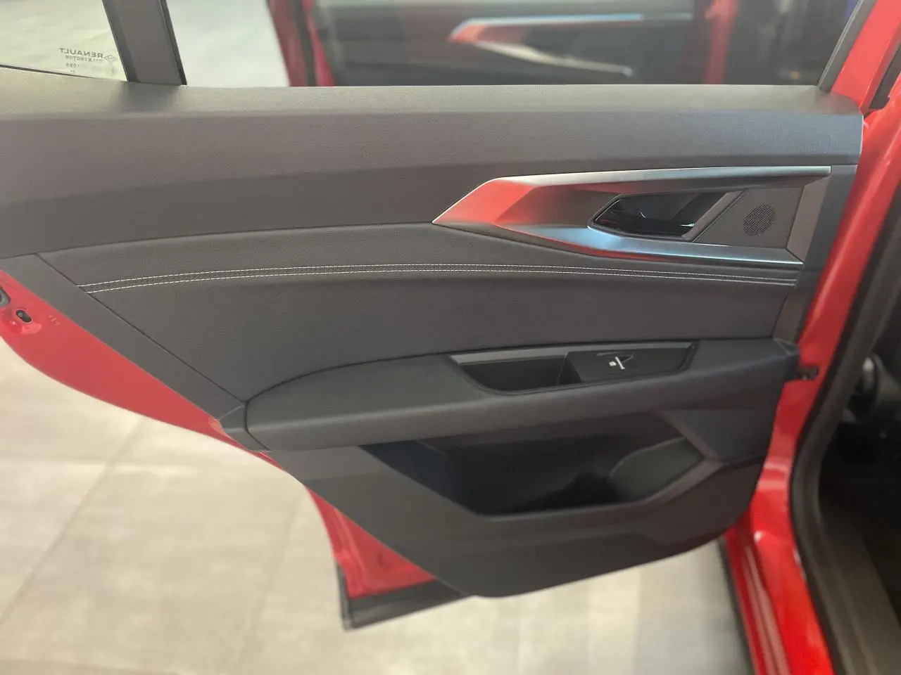 Vue intérieure côté gauche de la porte arrière rouge du Renault Rafale 2025 avec garniture noire et surpiqûres argentées.