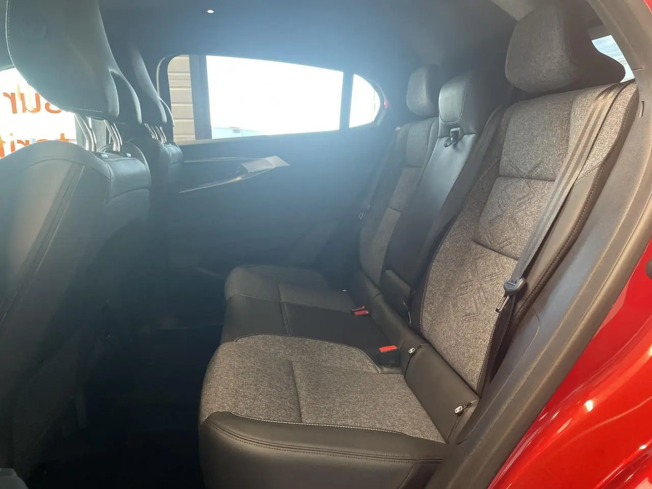 Vue latérale intérieure montrant la banquette arrière bi-matière gris clair et noir dans une Renault Rafale rouge.