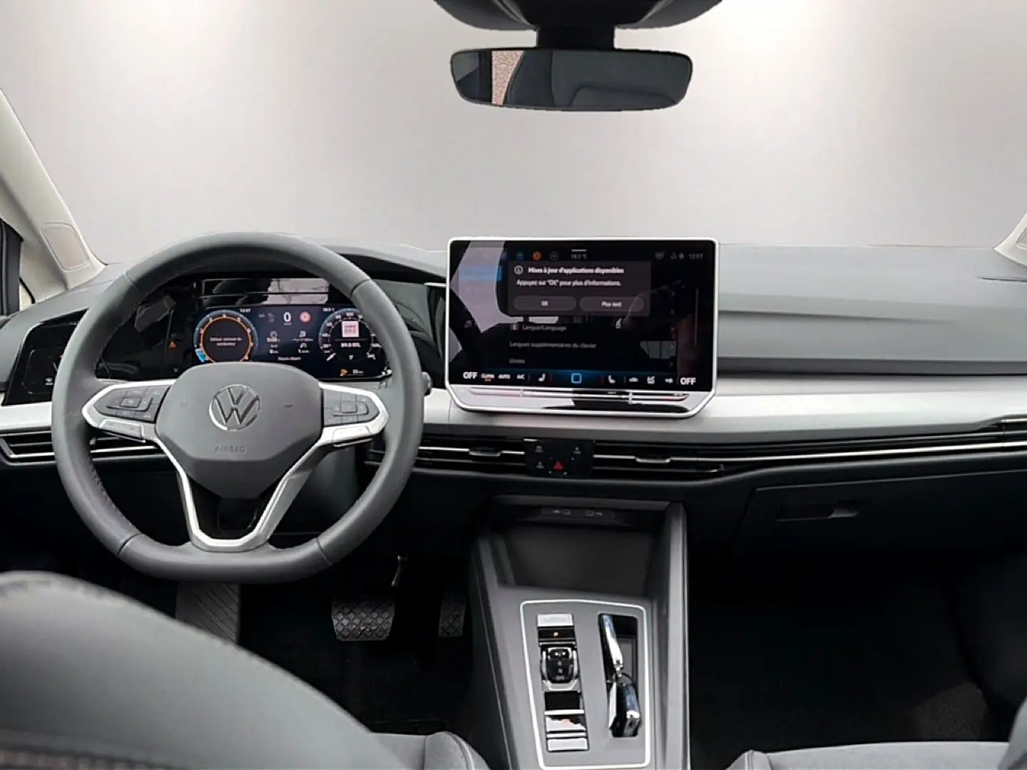 Vue intérieure avant de la Volkswagen Golf 1.5 etsi evo2 116 life dsg7 avec tableau de bord digital et volant gris.