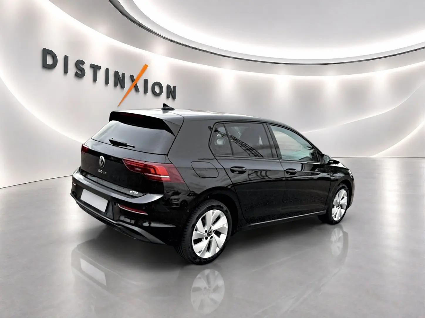 Volkswagen Golf noir vue 3/4 arrière droit dans un showroom avec jantes alu 17 pouces et vitres teintées.