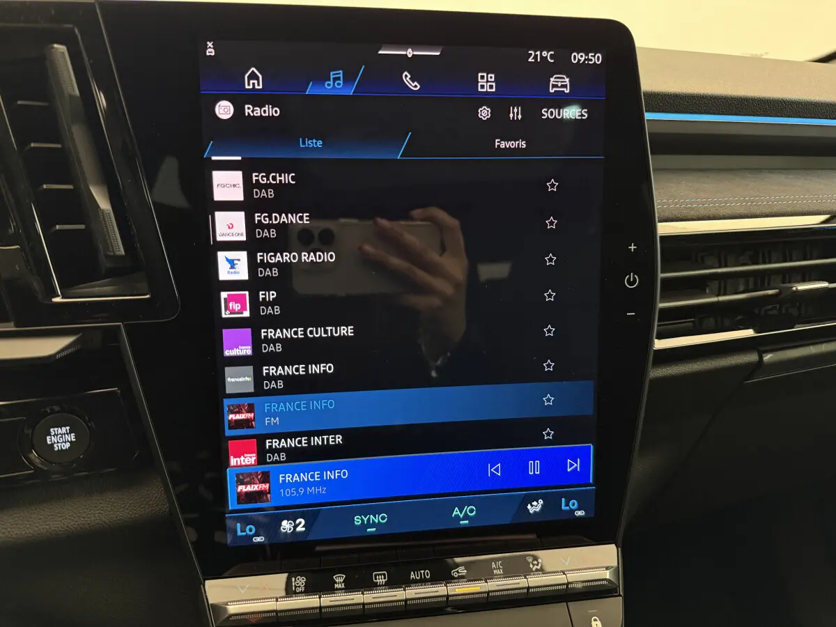 Écran tactile central du tableau de bord du Renault Espace gris foncé, affichant les stations radio DAB et FM.