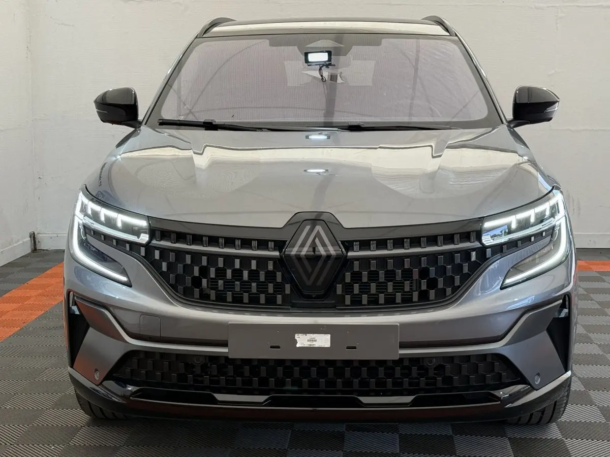 Vue frontale d'un Renault Espace gris foncé esprit Alpine 7 places avec calandre noire et phares LED allumés.