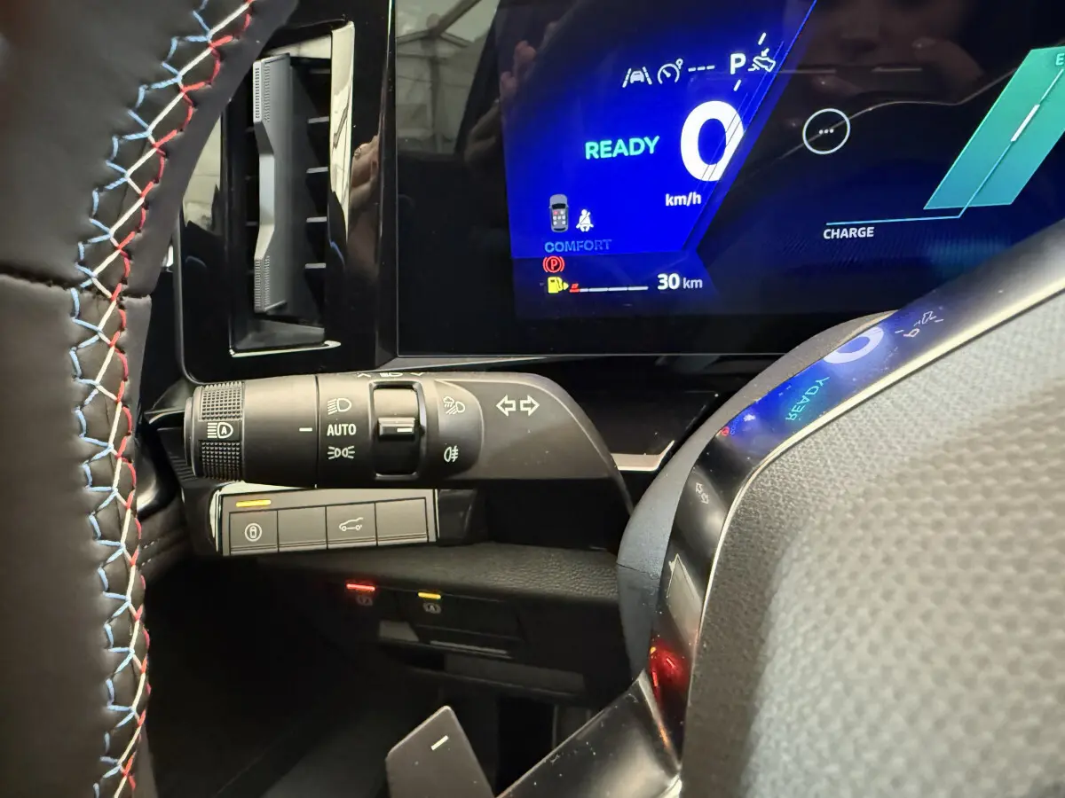 Gros plan sur le combiné d'instruments numérique bleu et la commande des phares du Renault Espace gris foncé esprit Alpine 2025.