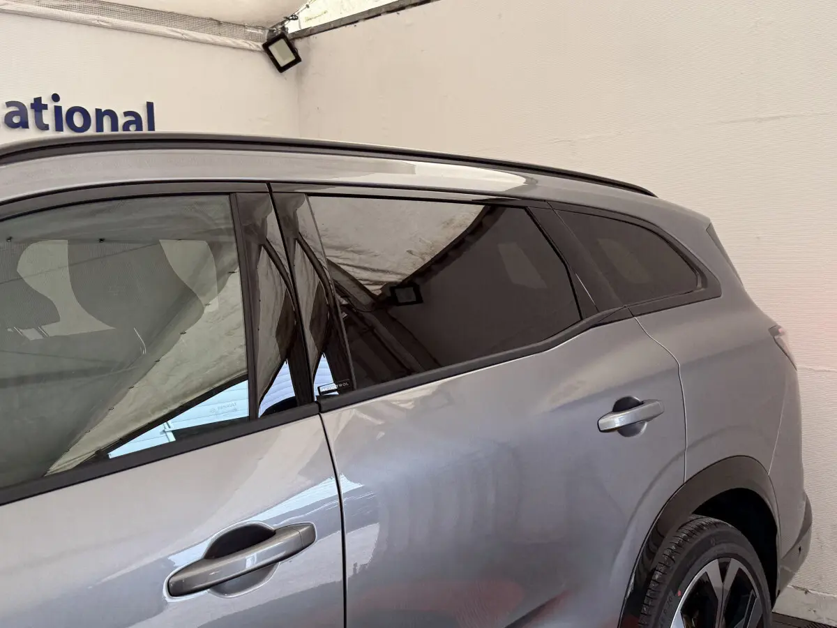 Vue latérale côté droit du Renault Espace gris foncé esprit Alpine 7 places avec vitres teintées et poignées intégrées.