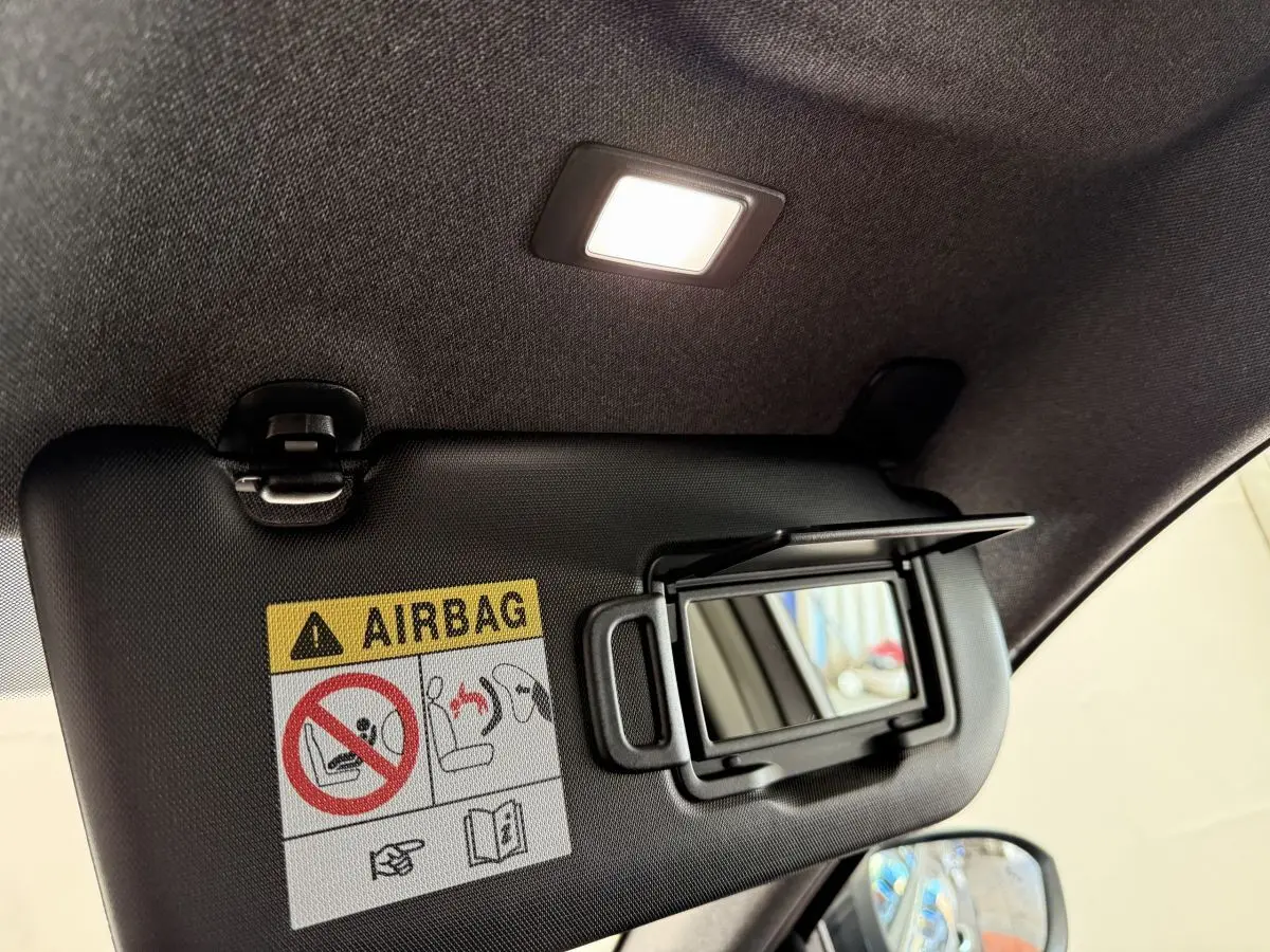 Détail du pare-soleil intérieur avec miroir et avertissement airbag dans un Renault Espace gris foncé 2025.