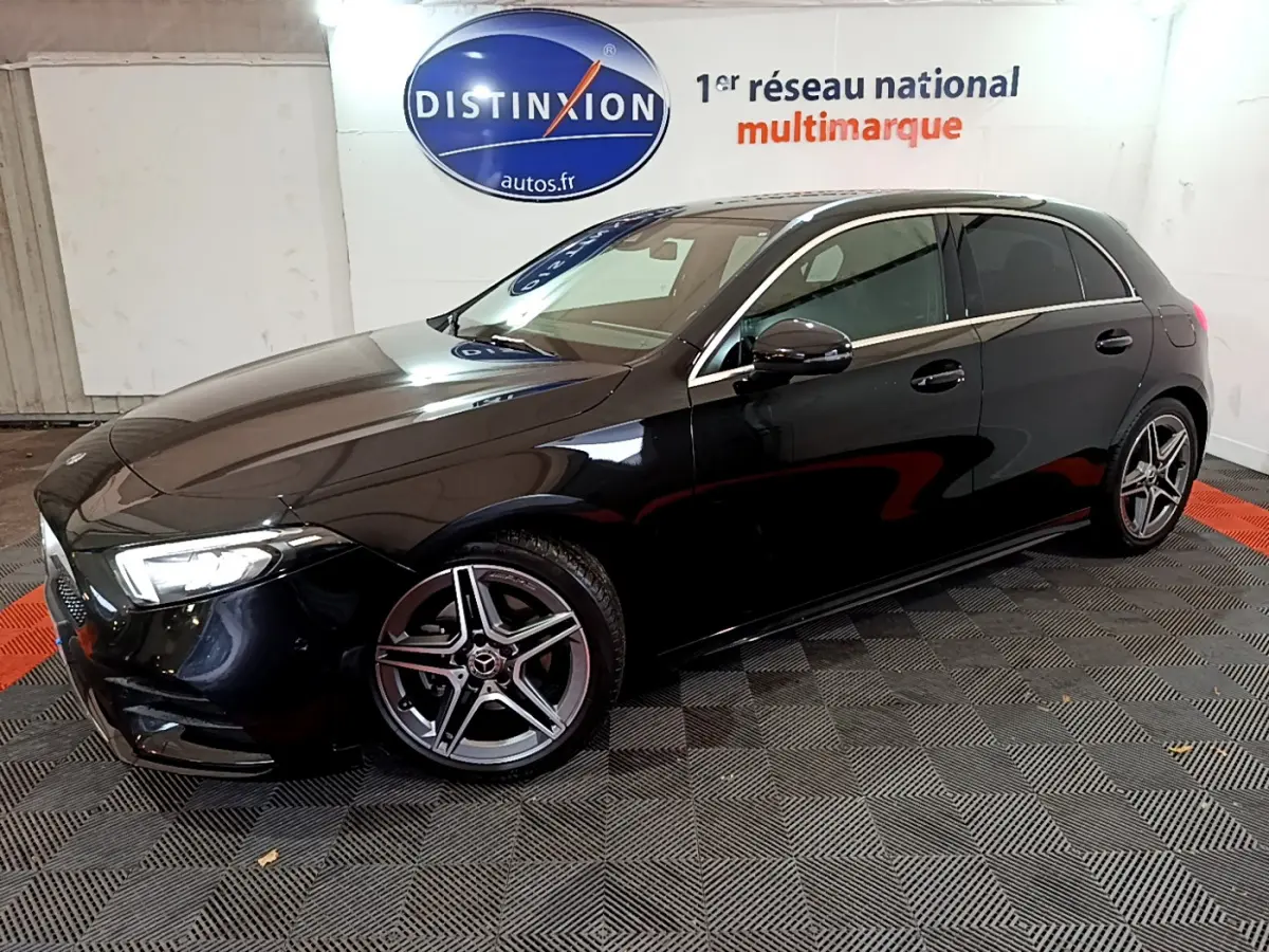 Mercedes Classe A 180 AMG Line noire vue de profil côté gauche, avec jantes alliage à cinq branches et phares LED allumés.