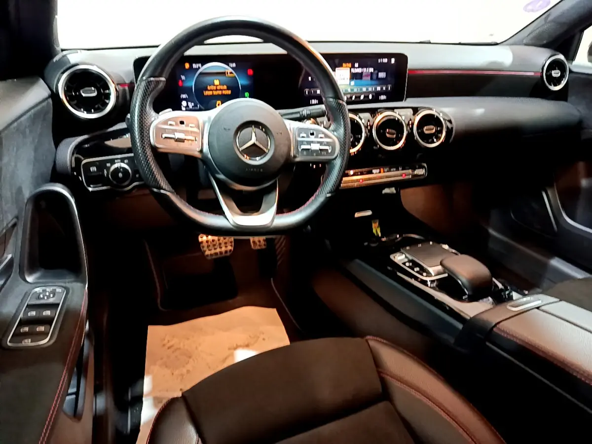 Intérieur noir de la Mercedes Classe A 180 AMG Line 2019, vue de face sur le volant et tableau de bord digital.
