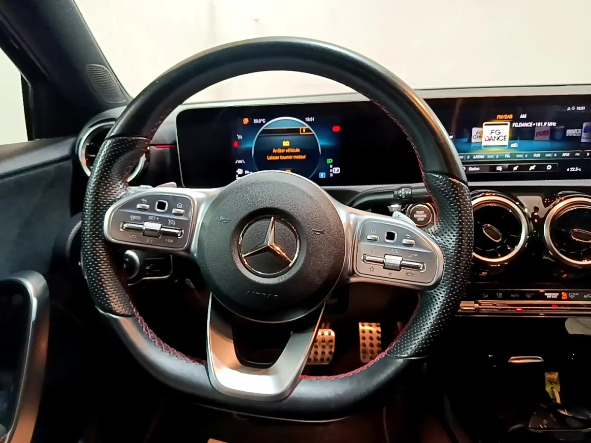 Volant cuir perforé avec commandes multifonctions et tableau de bord numérique d'une Mercedes Classe A 180 AMG Line 2019.