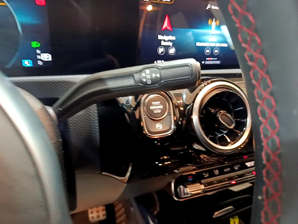 Détail intérieur du tableau de bord de la Mercedes Classe A 180 AMG Line 2019, avec bouton start et aérateur rond.