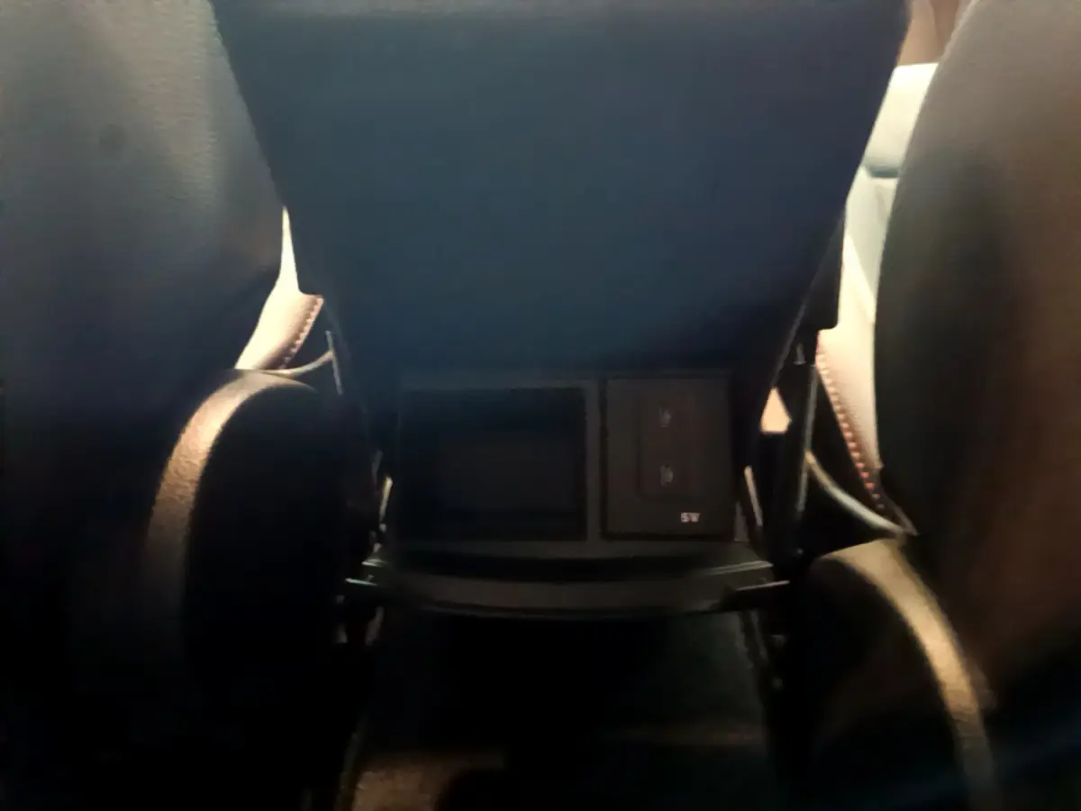 Prise USB et rangement sous l'accoudoir arrière entre les sièges noirs du Mercedes Classe A 180 AMG Line 2019.