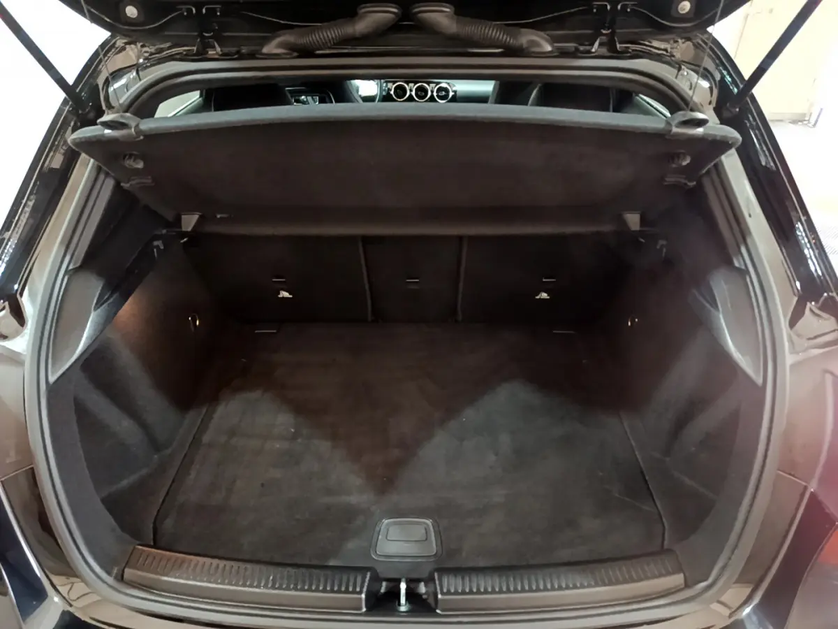 Coffre ouvert noir de la Mercedes Classe A 180 AMG Line 2019, vue arrière montrant l'espace de chargement vide.