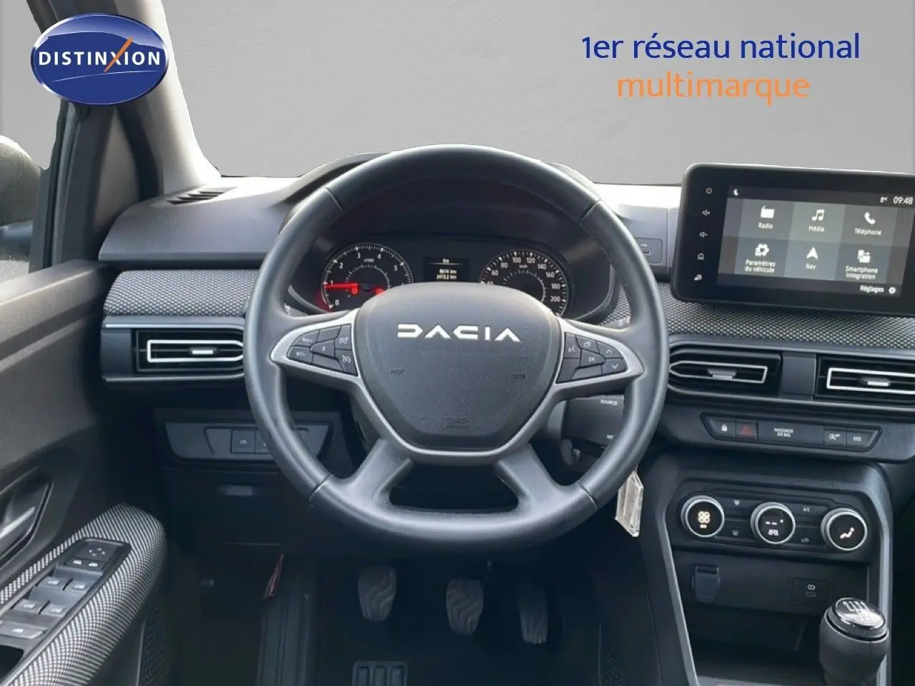 Vue intérieure centrée sur le volant DACIA d’un Jogger 2025, avec tableau de bord et écran tactile visibles.