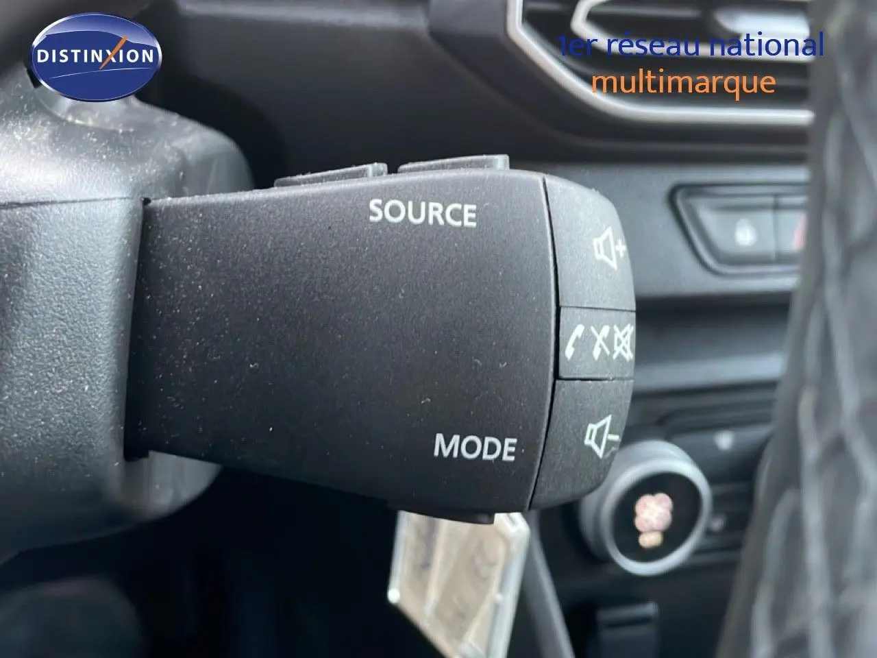 Gros plan sur la commande au volant du Dacia Jogger 2025, finition Expression, avec boutons source et mode visibles.