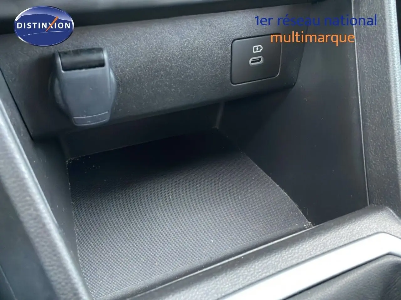 Gros plan sur la prise USB et l’allume-cigare dans le rangement intérieur du Dacia Jogger gris schiste métal.