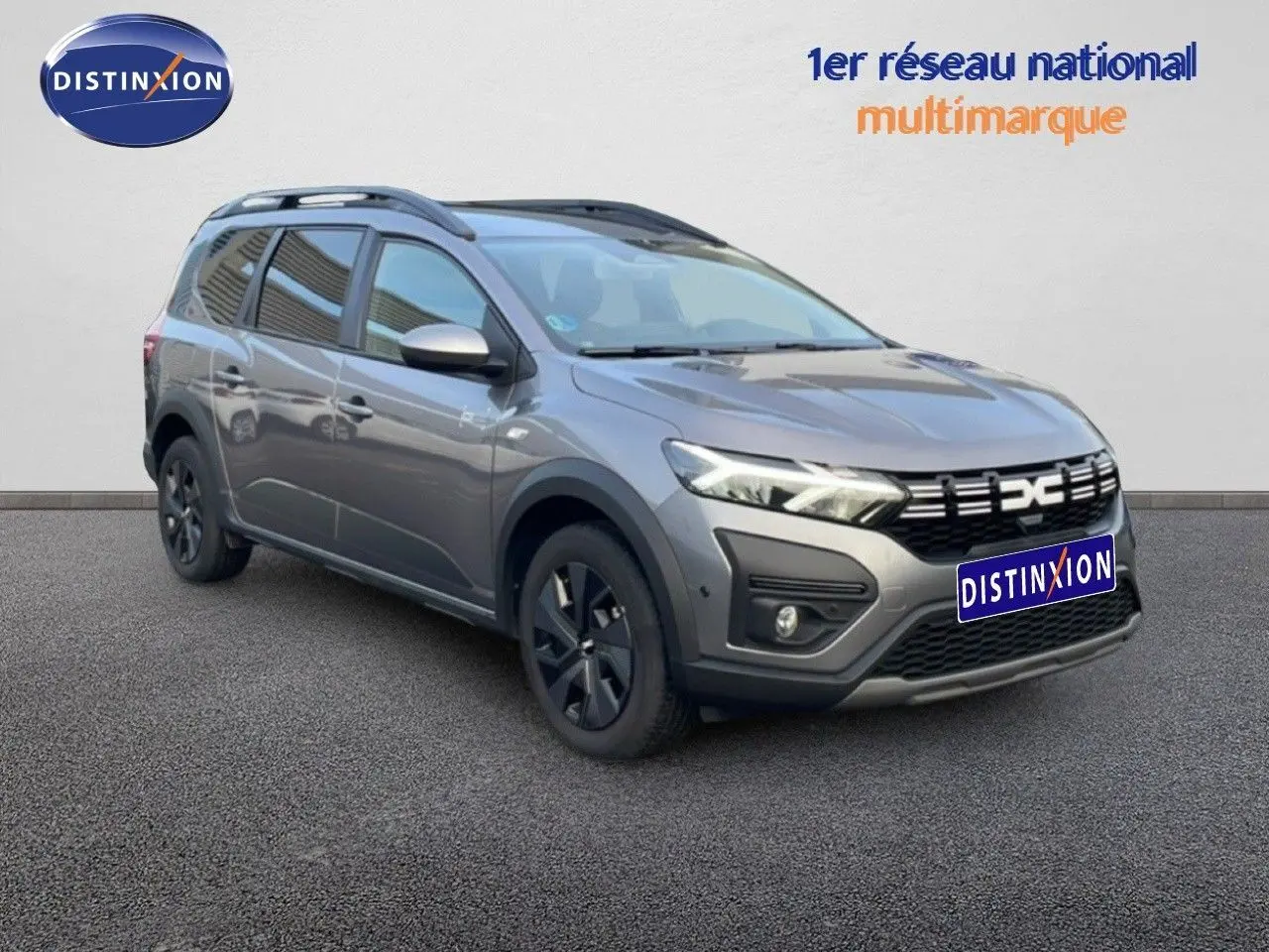 Dacia Jogger gris schiste métal en 3/4 avant droit, avec toit noir et jantes foncées sur fond neutre.