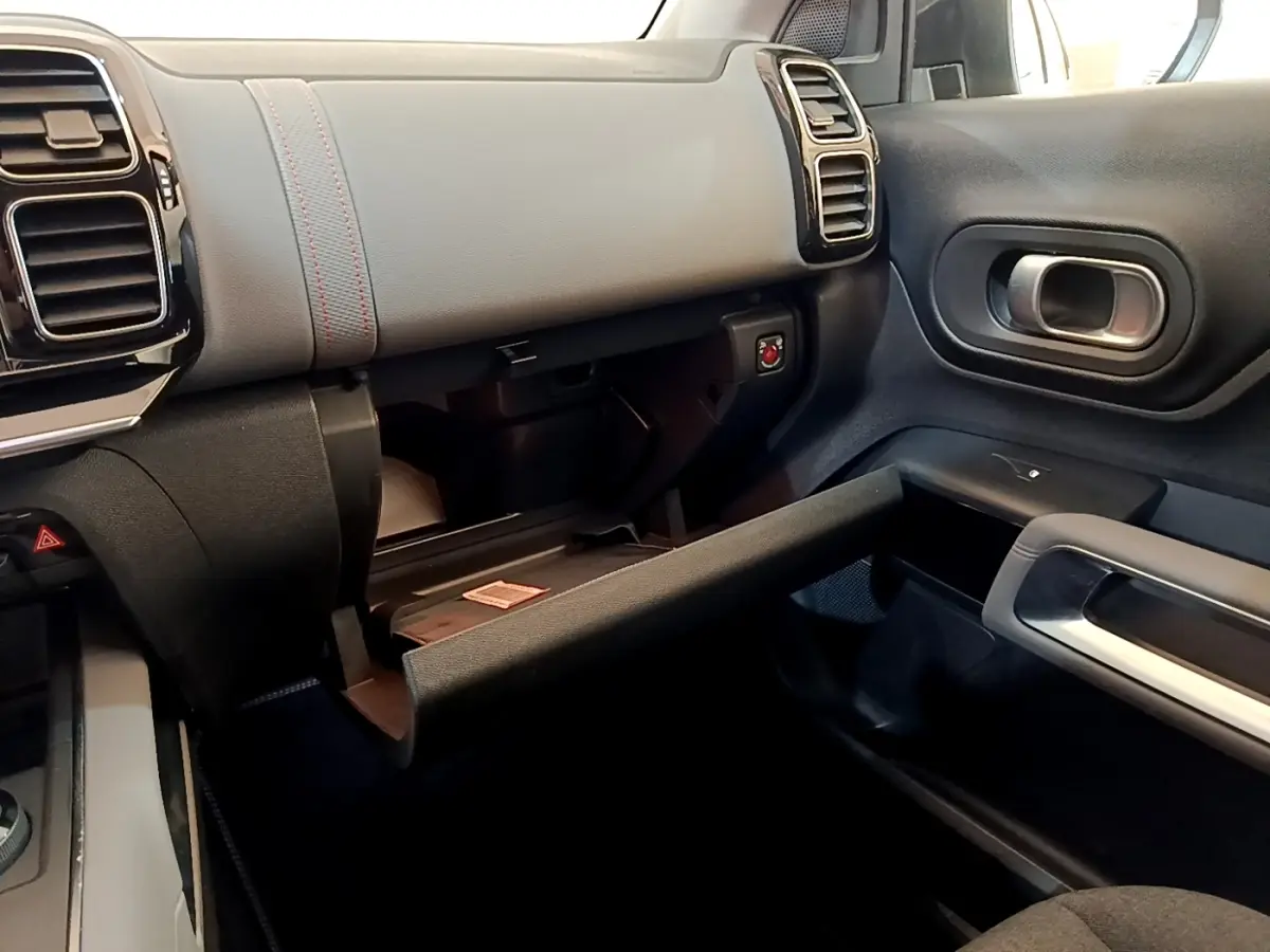 Intérieur du Citroën C5 Aircross 2020, vue côté passager avec boîte à gants ouverte et tableau de bord gris foncé.