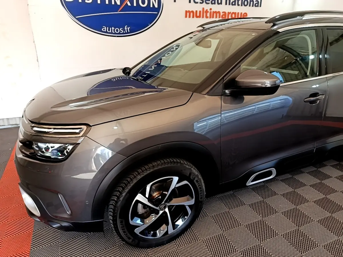 Vue 3/4 avant droit d’un Citroën C5 Aircross gris foncé avec jantes alliage et rétroviseurs électriques chromés.