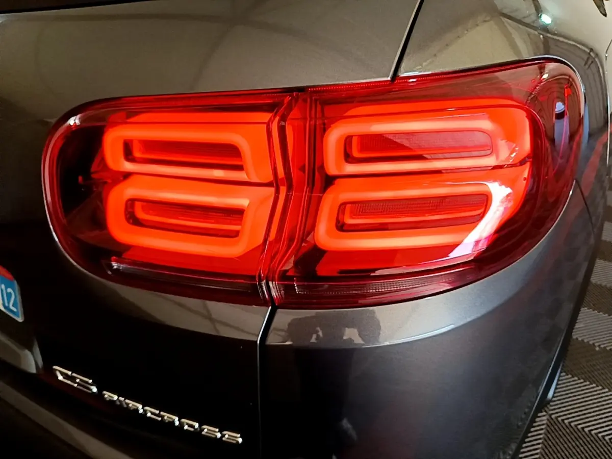 Gros plan sur le feu arrière droit rouge vif d’un Citroën C5 Aircross gris foncé, avec logo et partie de la plaque visible.