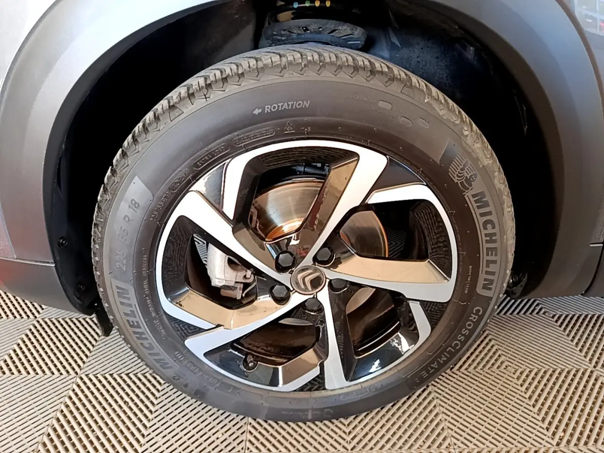 Gros plan sur la roue avant droite du Citroën C5 Aircross gris foncé, jante alliage bicolore et pneu Michelin.