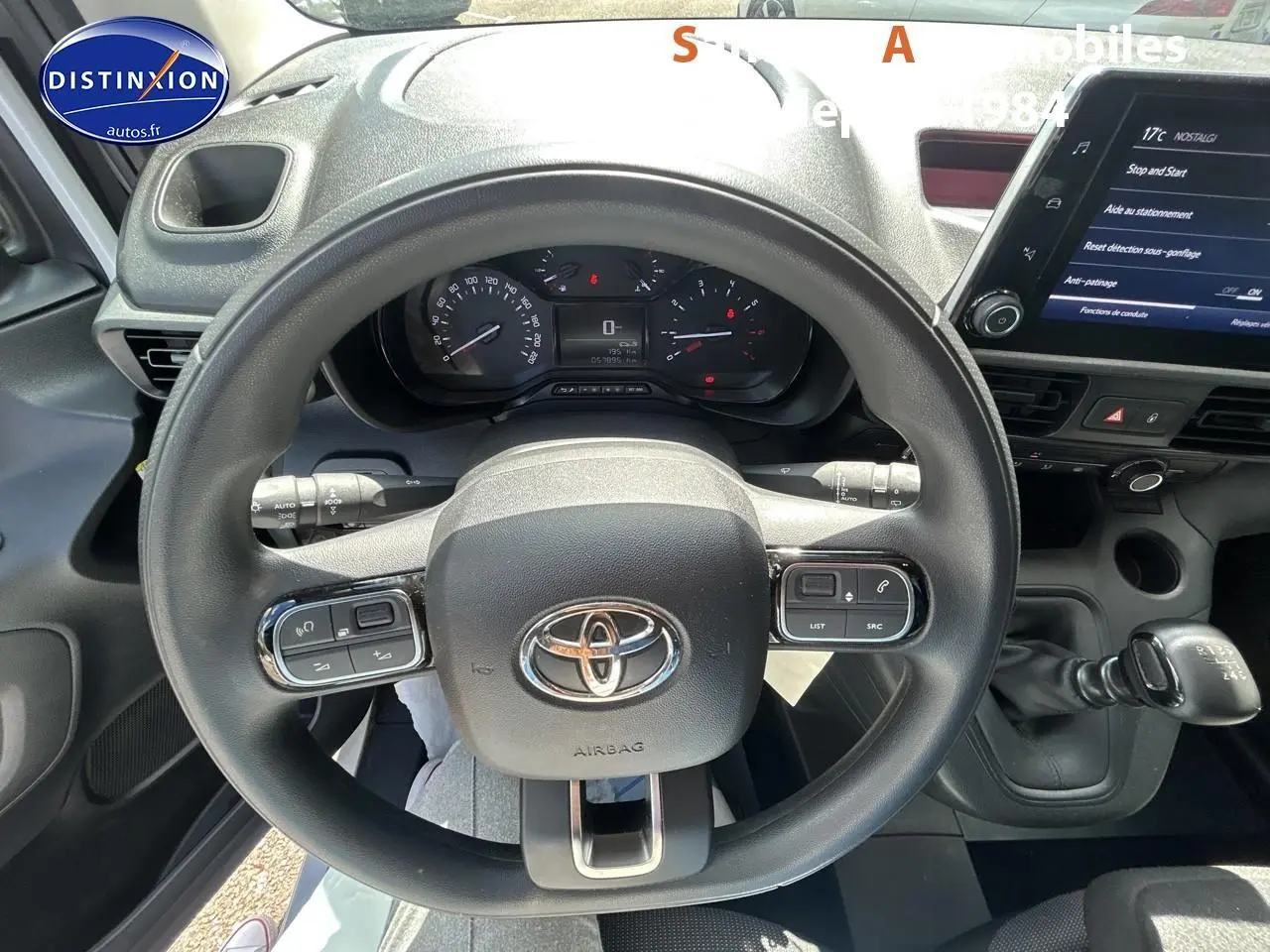 Vue intérieure centrée sur le volant noir du Toyota Proace City 2023 avec tableau de bord et levier de vitesses manuel.
