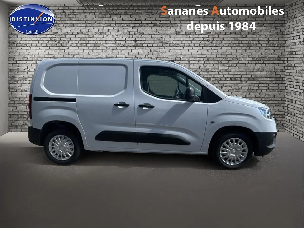 Vue de profil côté gauche du Toyota Proace City blanc 2023 avec porte latérale tôlée et coques de rétroviseurs noires.