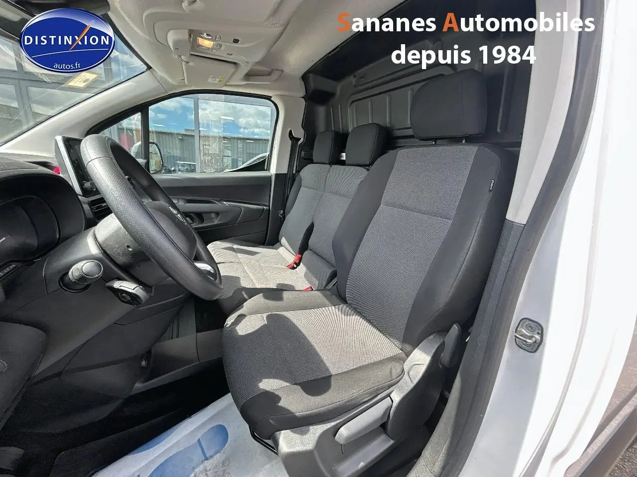 Vue intérieure côté conducteur du Toyota Proace City blanc 2023, montrant la banquette passager 2 places et le tableau de bord.