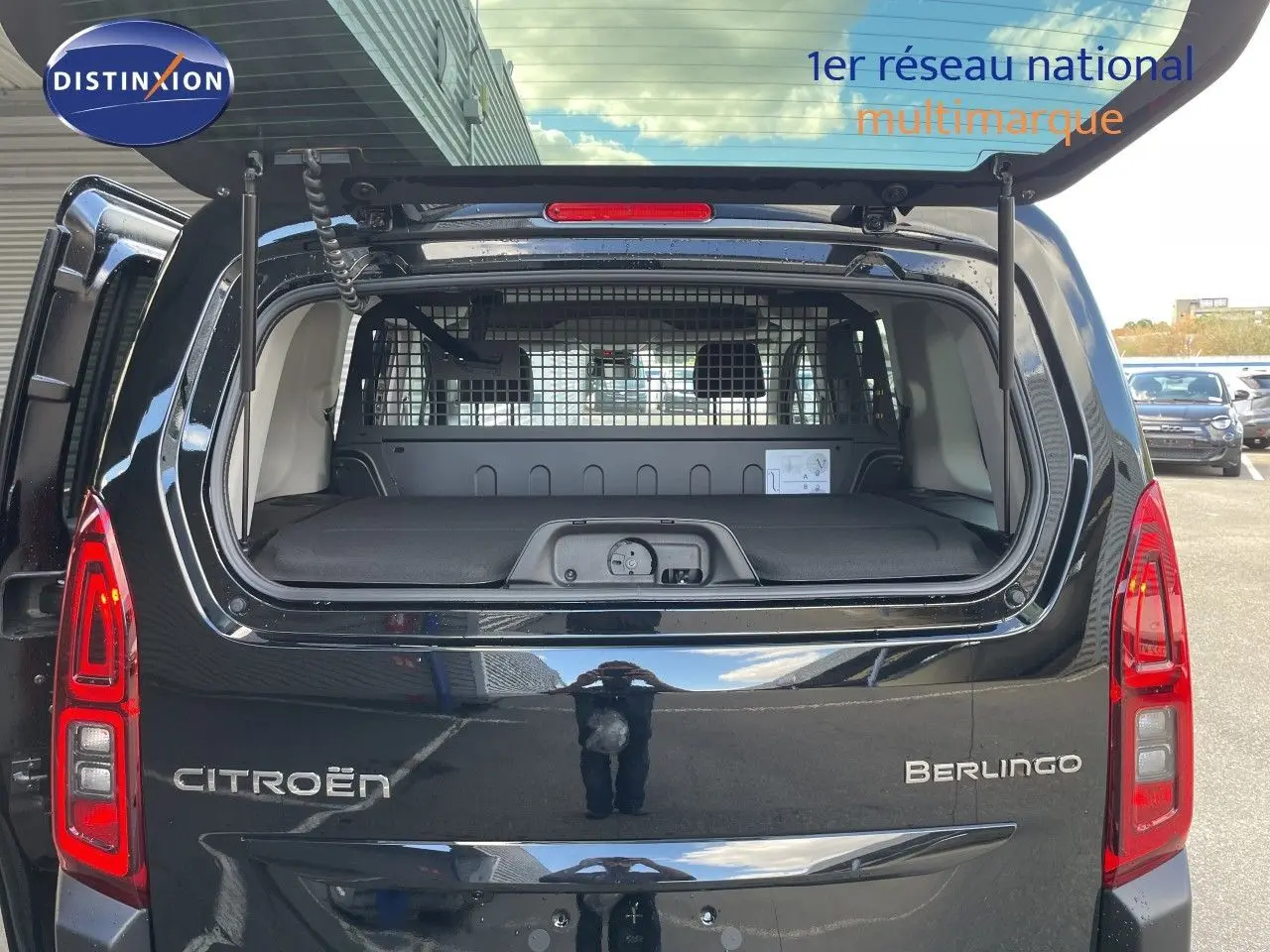 Vue arrière du Citroën Berlingo noir Perla Nera avec hayon ouvert, montrant l'espace de chargement et la grille de séparation.