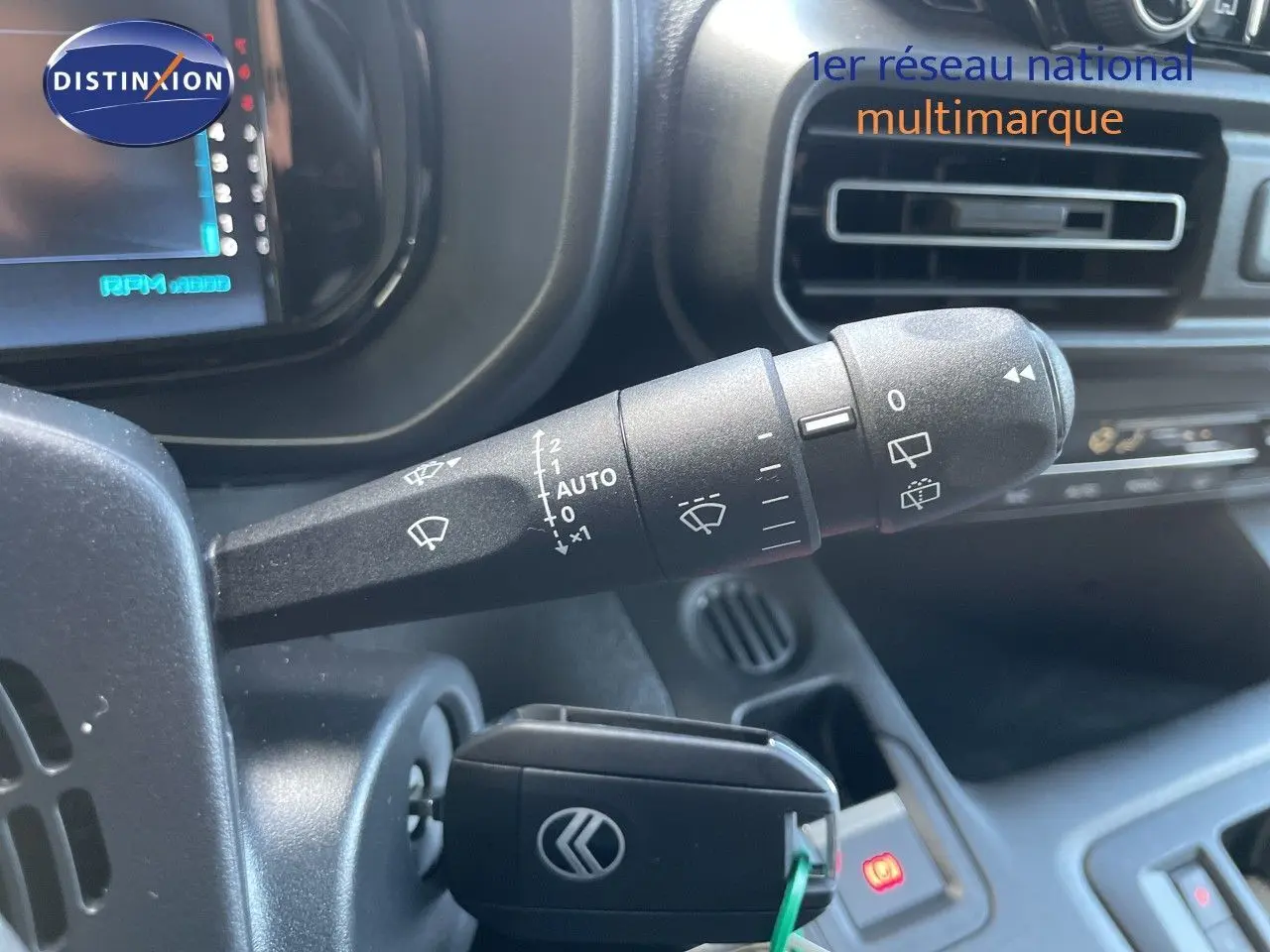 Gros plan sur la commande d’essuie-glace et le contacteur d’un Citroën Berlingo noir Perla Nera, intérieur noir visible.