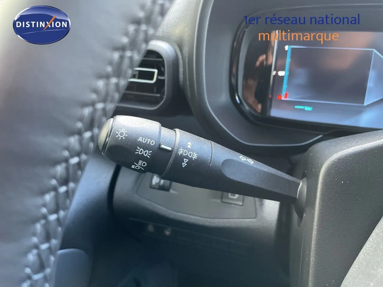 Gros plan sur la commande des feux et clignotants à gauche du volant dans un Citroën Berlingo noir Perla Nera 2026.