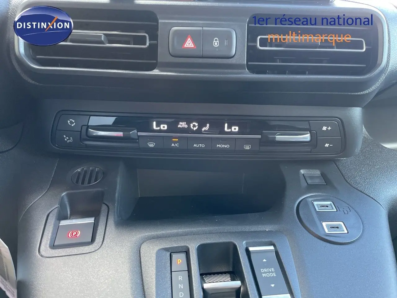 Gros plan sur la console centrale du Citroën Berlingo noir, montrant la climatisation digitale et la commande de boîte automatique.