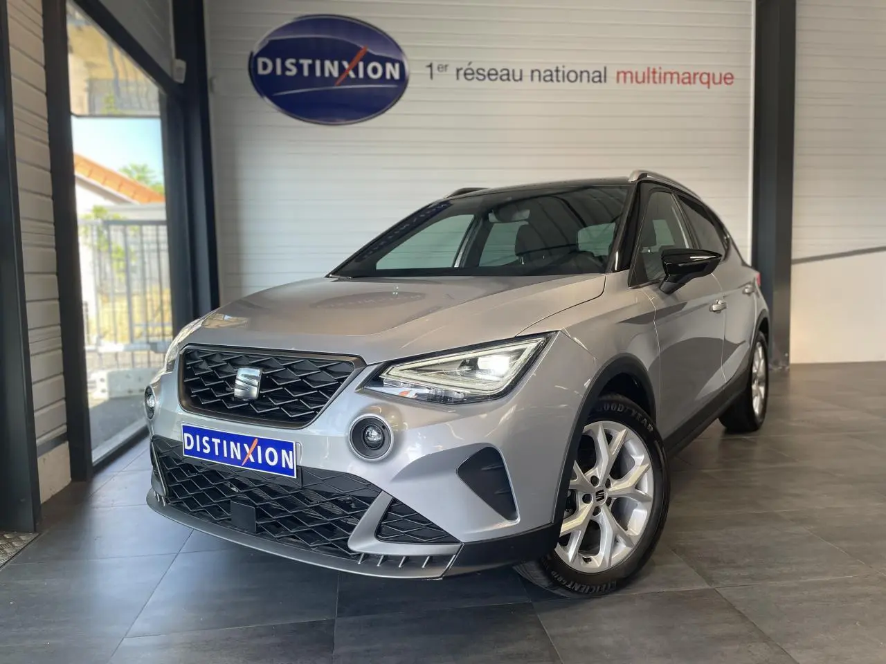 SEAT Arona 2024 gris GRS en 3/4 avant droit, avec jantes alliage et calandre noire distinctive.