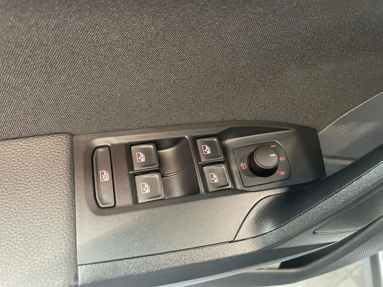 Panneau de commandes des vitres et rétroviseurs côté conducteur du SEAT Arona 2024 en intérieur noir.