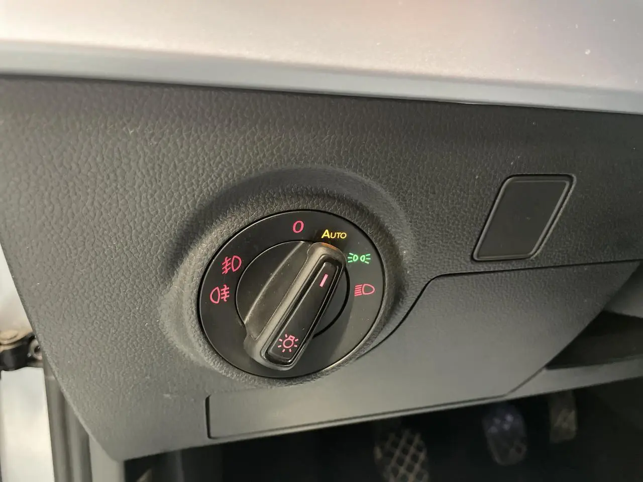 Gros plan sur le bouton de commande des phares dans l’habitacle du SEAT Arona 2024, finition FR, couleur GRS.