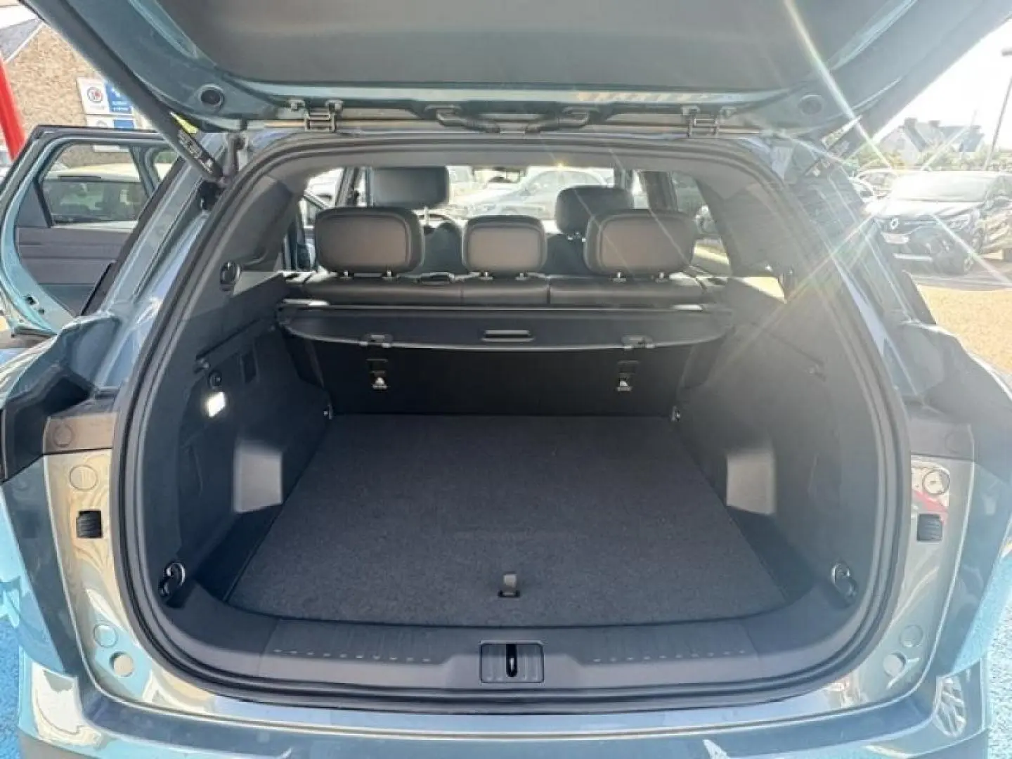 Vue arrière ouverte du coffre spacieux du JAECOO J7 1.5 TGDI en Olive Grey Métal avec intérieur sombre.