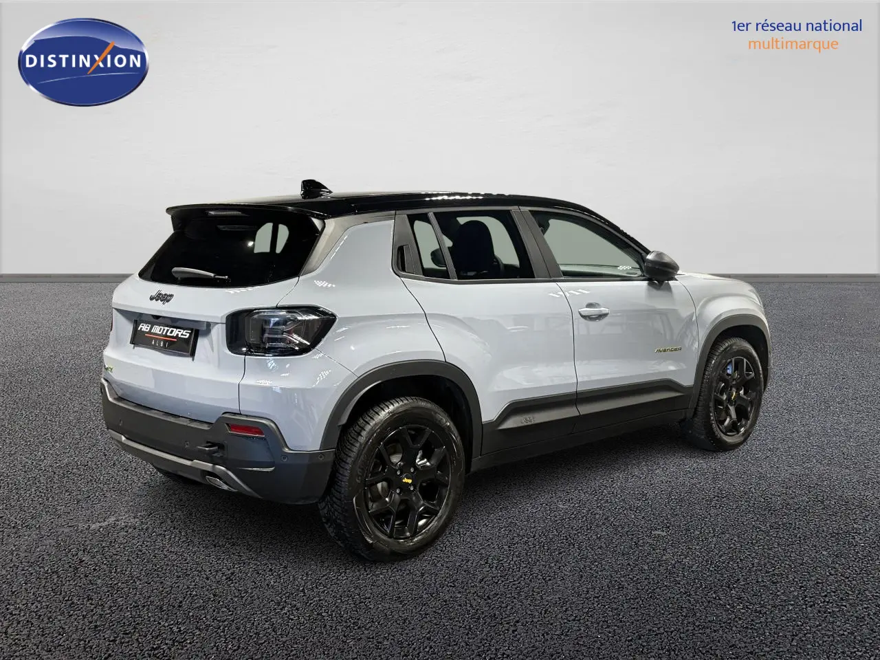 Jeep Avenger Hybrid 4xe gris clair vue 3/4 arrière avec toit noir et jantes alliage noires.