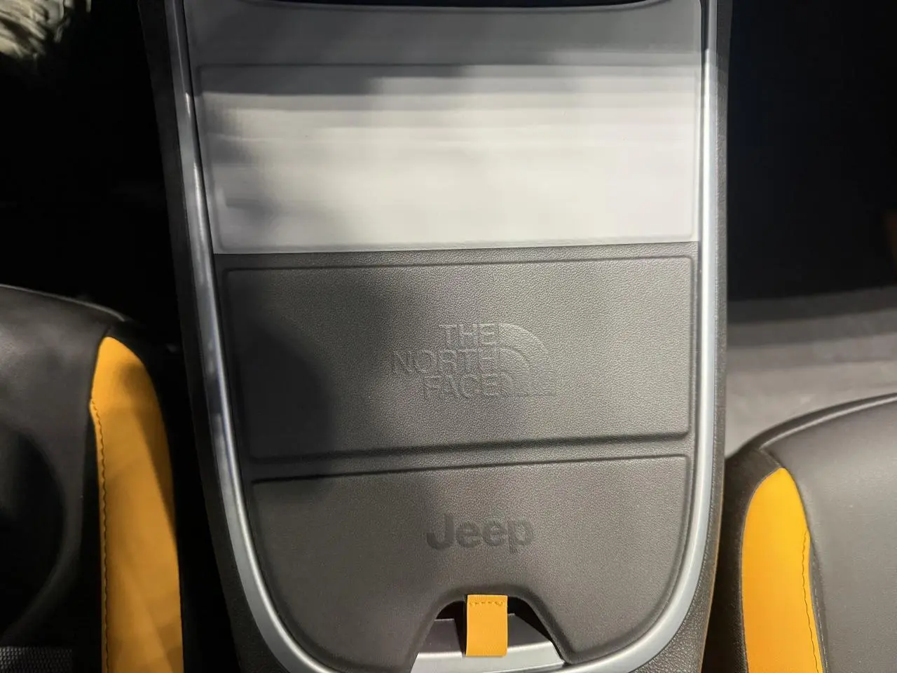 Gros plan sur la console centrale noire avec logo The North Face et Jeep, sellerie noire et jaune visible.