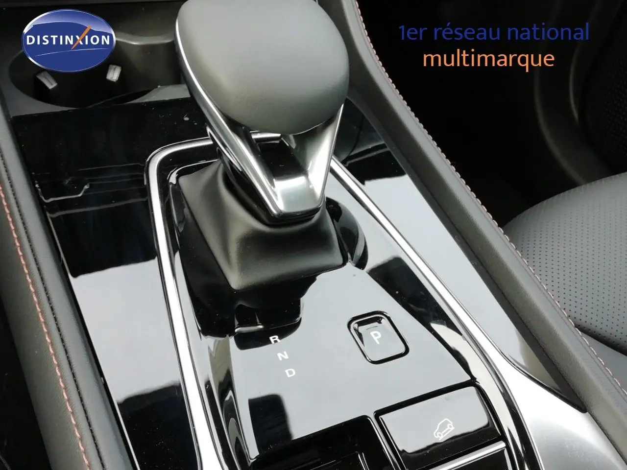 Gros plan sur la commande de boîte automatique noire brillante du MG MOTOR EHS 1.5T PHEV 272CH LUXURY, intérieur cuir noir.