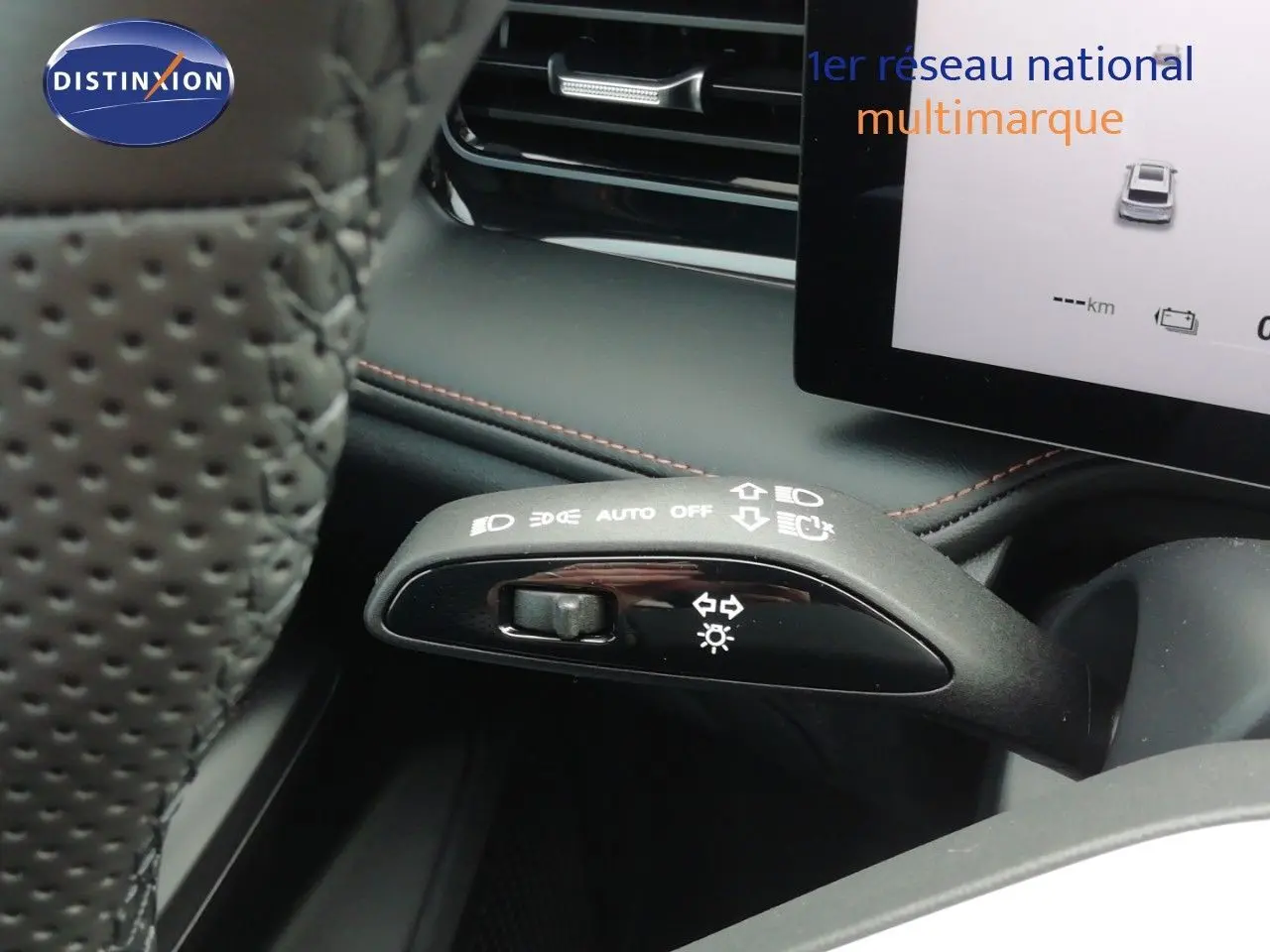 Gros plan sur la manette de commandes d'éclairage du MG MOTOR EHS 1.5T PHEV 272CH Luxury, intérieur noir avec surpiqûres rouges.