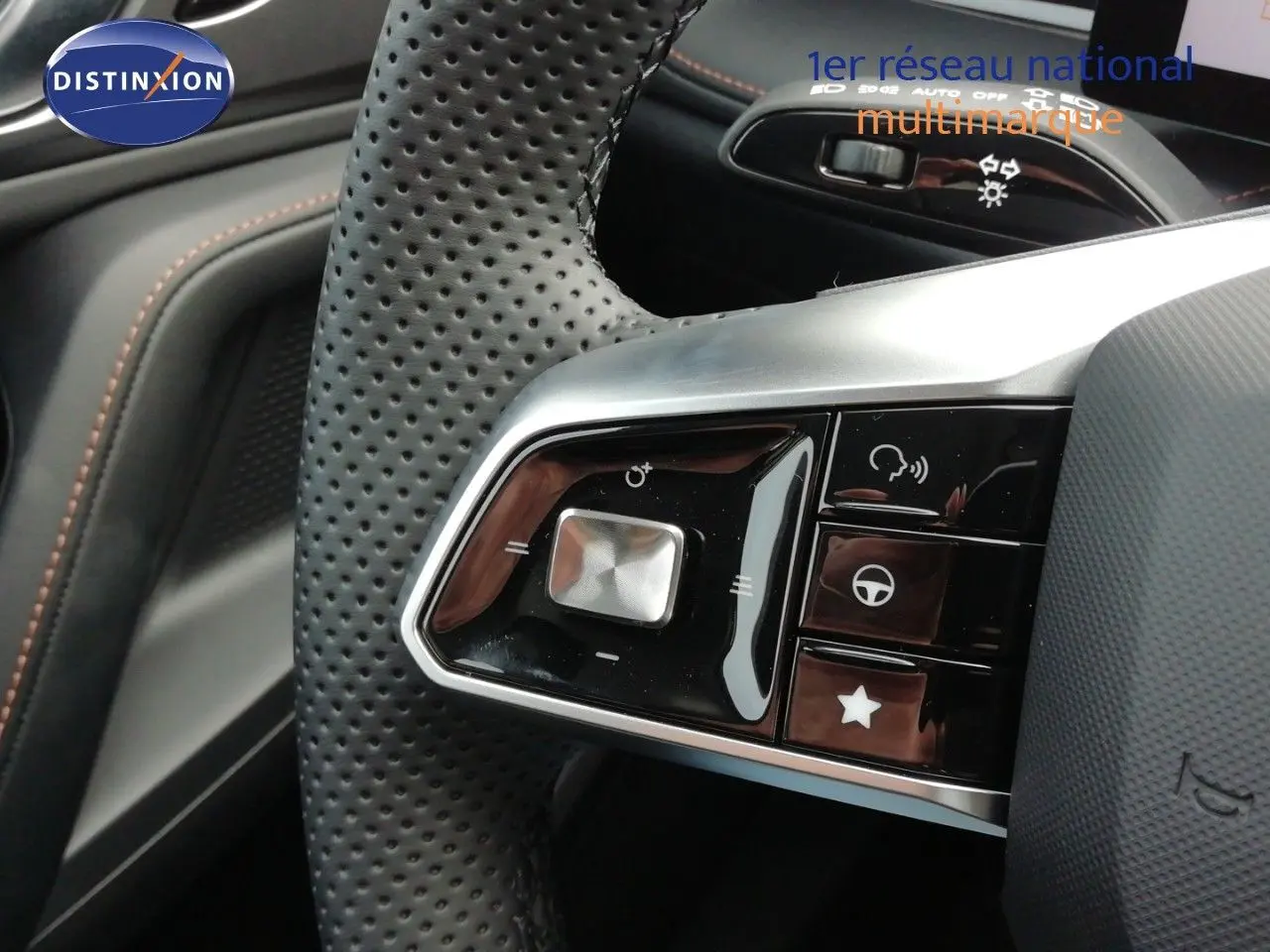 Gros plan sur les commandes du volant en cuir perforé noir du MG MOTOR EHS 1.5T PHEV 272CH LUXURY, intérieur noir.