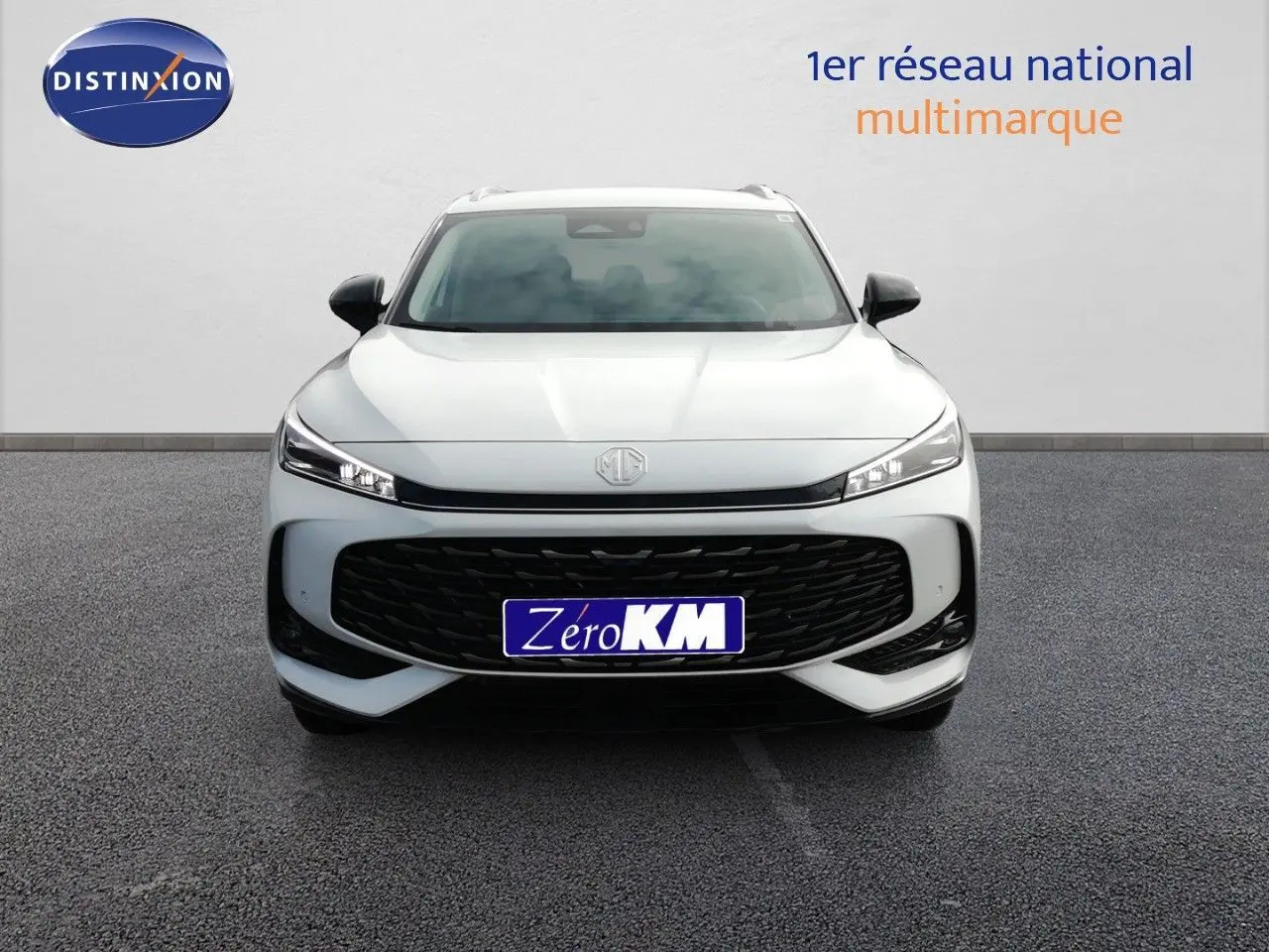 Vue frontale d'un MG MOTOR EHS 1.5T PHEV 272CH Luxury blanc nacré avec calandre noire et phares LED fins.