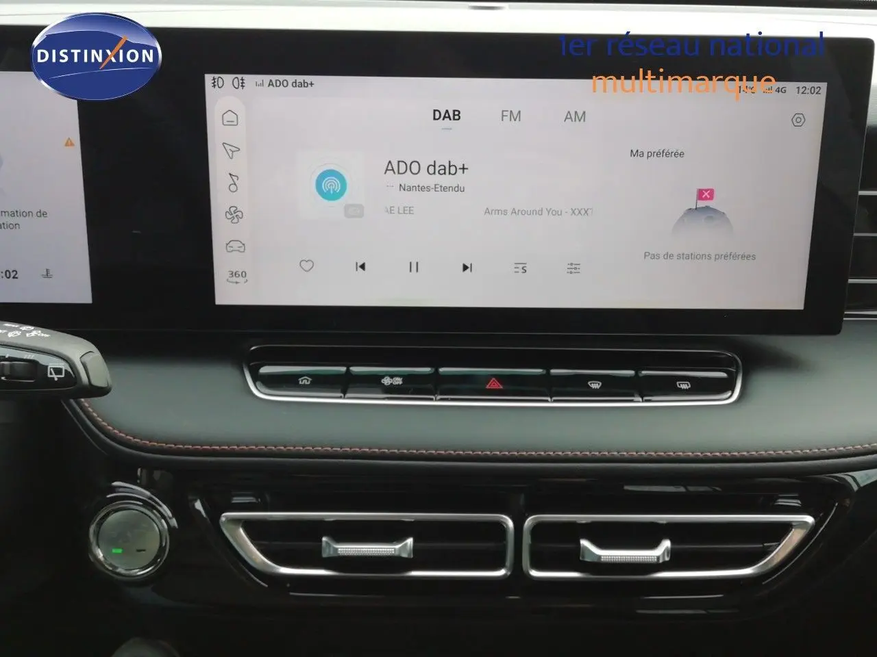 Vue rapprochée de l’écran tactile et de la console centrale noire du MG MOTOR EHS blanc perle, affichant la radio DAB.