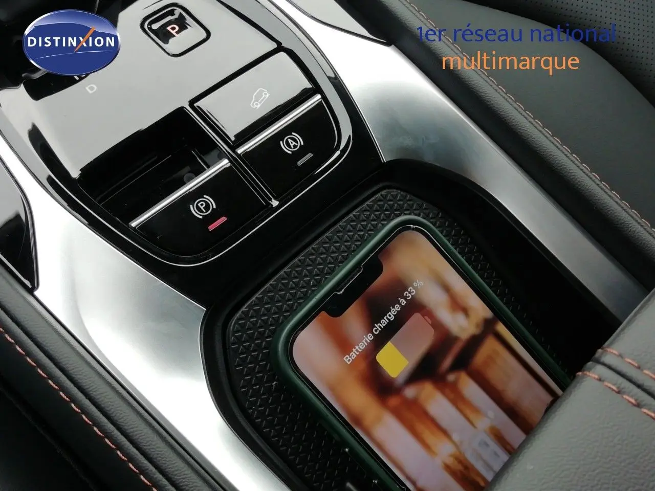 Gros plan sur la console centrale du MG MOTOR EHS 1.5T PHEV 272CH Luxury avec téléphone en charge sans fil.