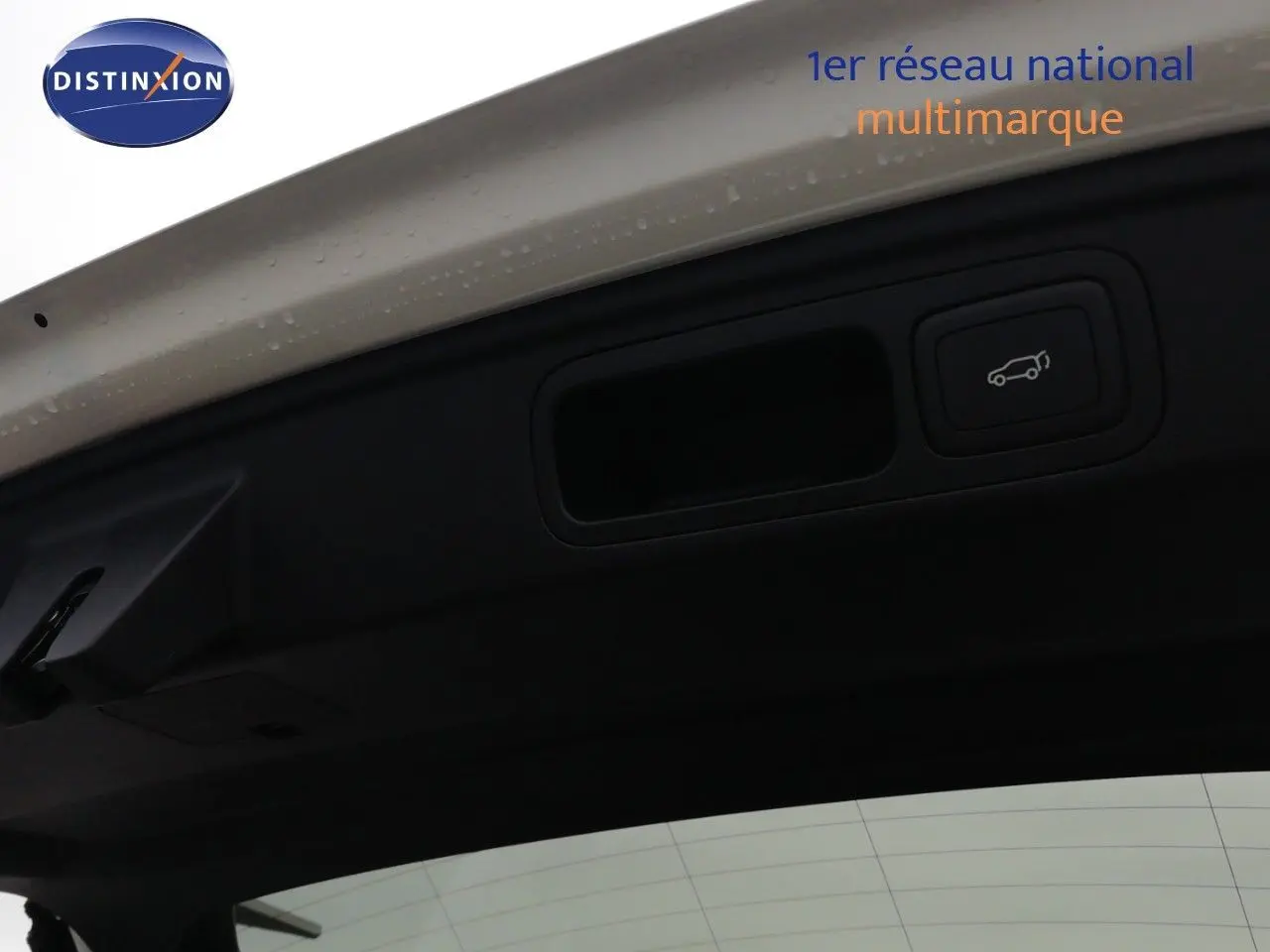 Détail du bouton d'ouverture électrique du coffre sur le hayon blanc nacré du MG MOTOR EHS 1.5T PHEV 2026.
