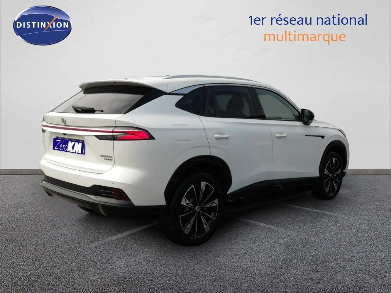 Vue 3/4 arrière droite du MG Motor EHS 1.5T PHEV 272CH Luxury en blanc nacré avec jantes bi-ton et vitres teintées.
