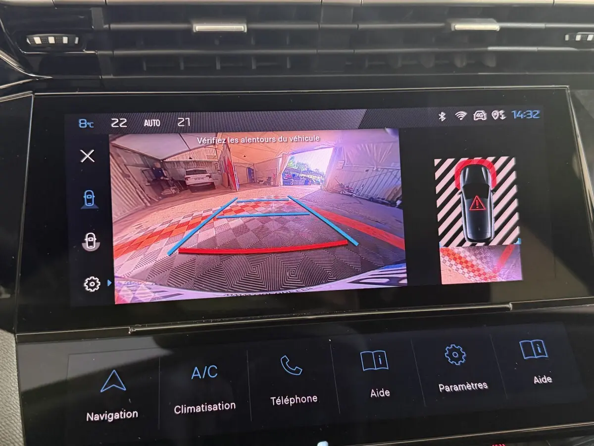Écran tactile de la Peugeot 308 bleu montrant la caméra de recul et l’aide au stationnement arrière en intérieur.