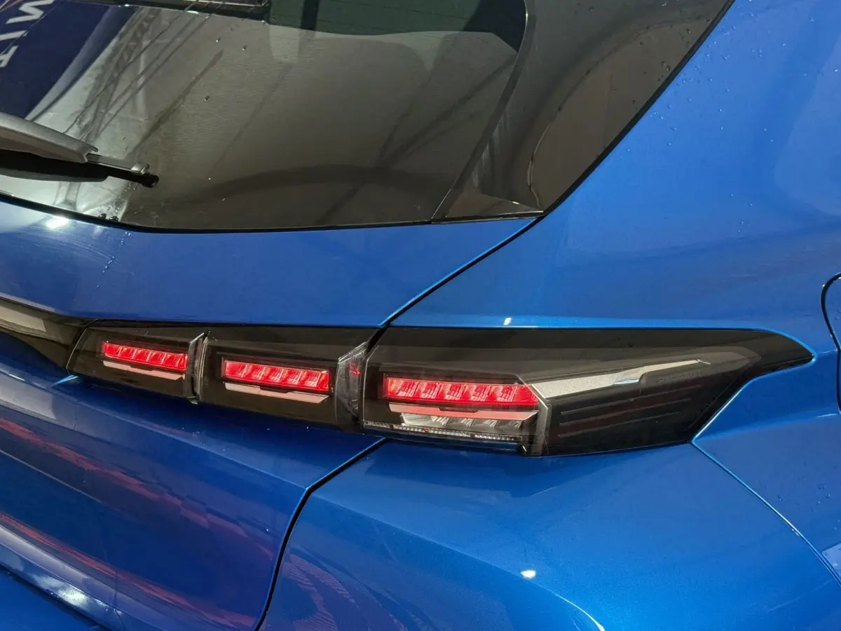 Feu arrière droit allumé d'une Peugeot 308 bleu 2023, vue rapprochée sur la partie arrière droite.