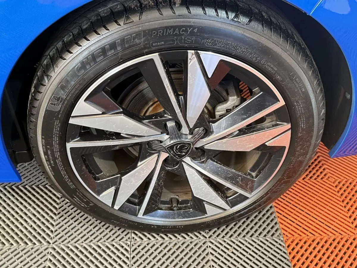 Gros plan sur la roue avant droite de la Peugeot 308 bleu 2023 avec jante alliage au design moderne et pneu Michelin.